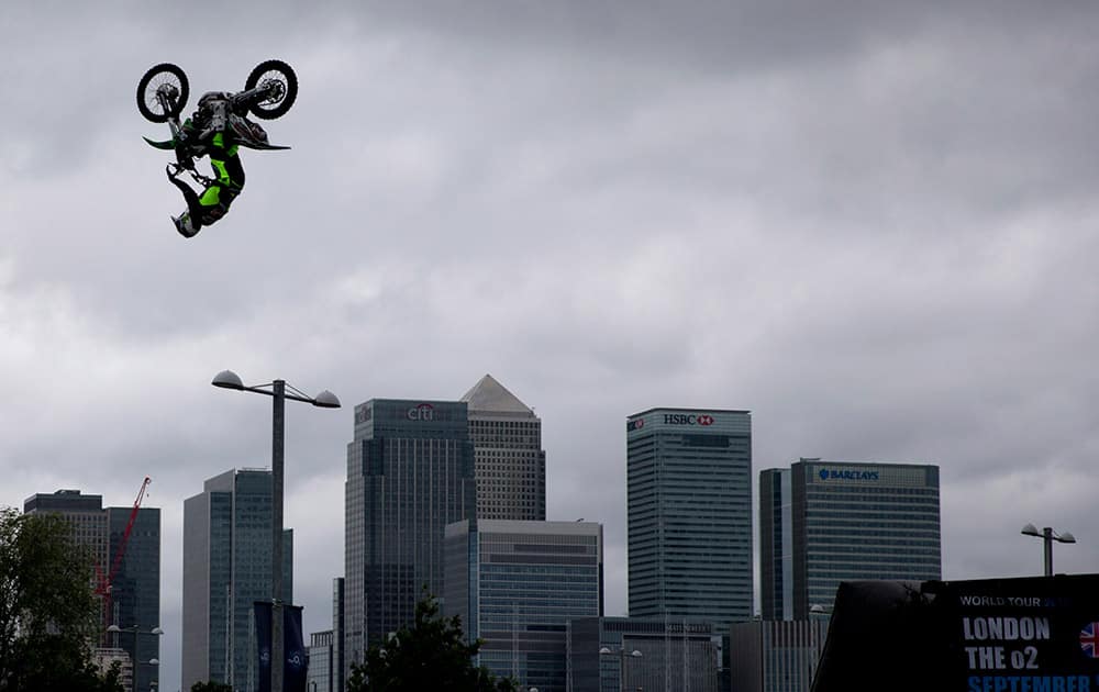 Britain's Jamie Squibb performs a jump on his motocross bike backdropped by the Canary Wharf business district during a promotional event in London. The publicity stunt Tuesday was to promote the freestyle motocross world tour event 
