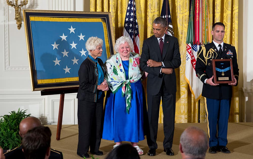 President Barack Obama posthumously bestows the Medal Of Honor for Army Sgt. William Shemin to his daughters Ina Bass, left, and Elsie Shemin-Roth, of suburban St. Louis, during a ceremony in the East Room of the White House in Washington.