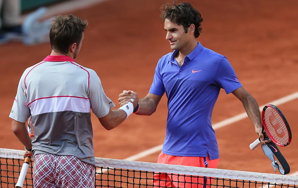 Switzerland's Stan Wawrinka shakes hands with compatriot Roger Federer, right, after winning the quarterfinal match of the French Open tennis tournament in three sets 6-4, 6-3, 7-6 (7-4), at the Roland Garros stadium, in Paris, France.