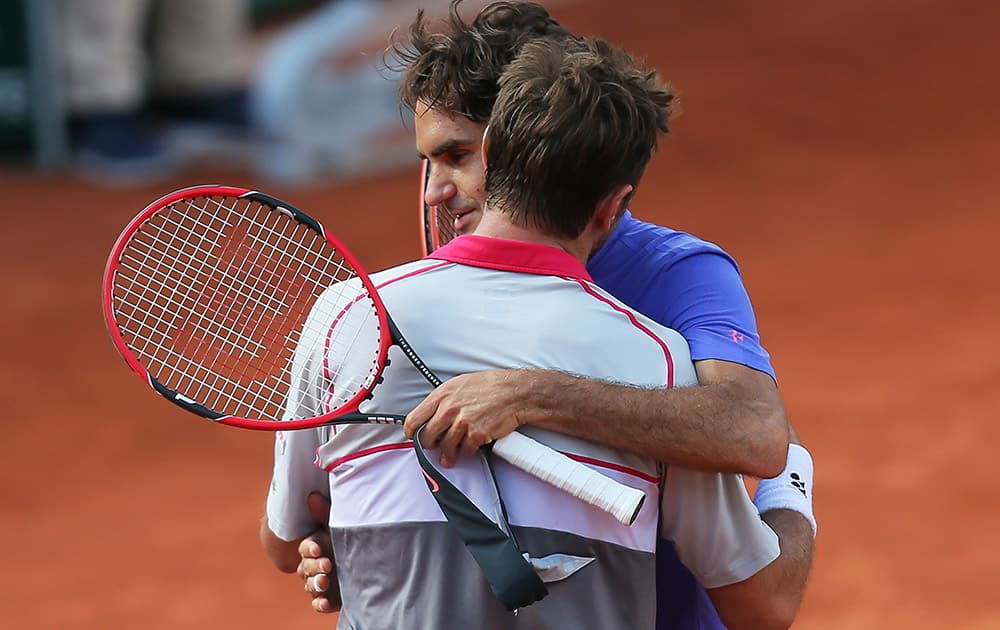 Switzerland's Stan Wawrinka hugs compatriot Roger Federer after winning in the quarterfinal match of the French Open tennis tournament in three sets 6-4, 6-3, 7-6 (7-4), at the Roland Garros stadium, in Paris, France.