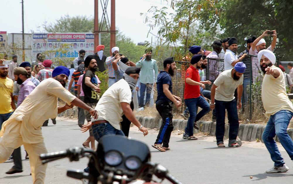 Jammu: Sikh protesters pelting stones at the police for removing a poster of Jarnail Singh (Bhindrawala) near airport.