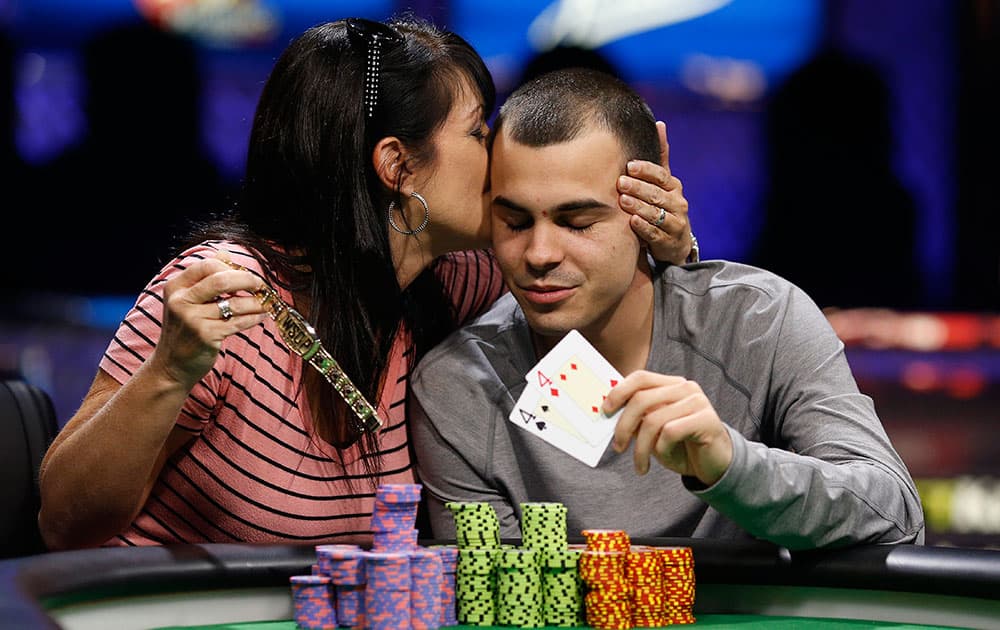 Lance Garcia gets a kiss from his mother, Kristen Scott, while posing for photographers after he won the World Series of Poker Colossus event, in Las Vegas. 