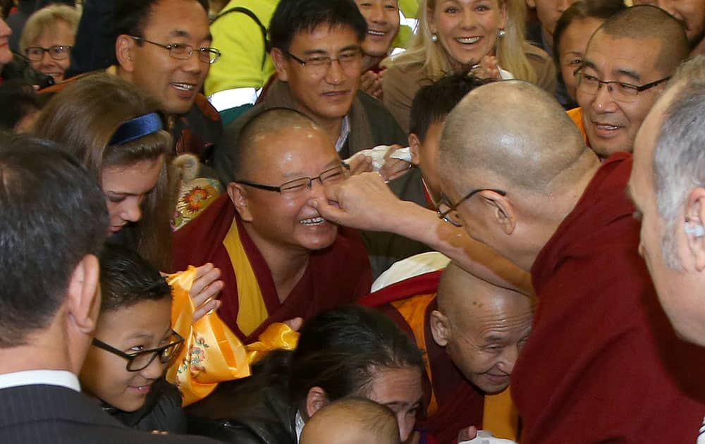 The Dalai Lama pinches the nose of a well-wisher as he arrives in Sydney.