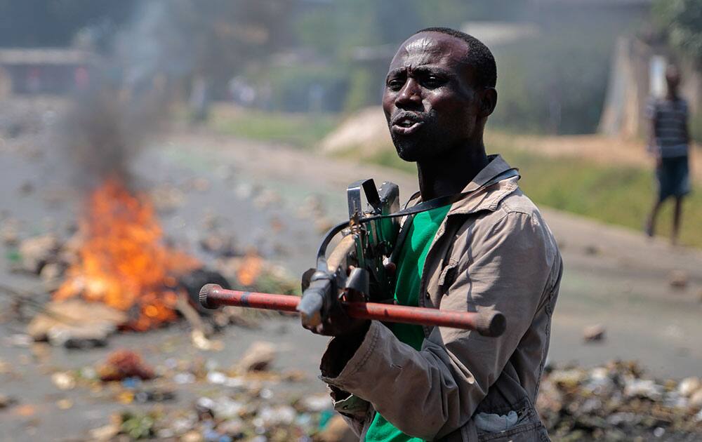 An opposition demonstrator points a mock gun made from wood towards soldiers and tells them it is shameful to shoot on people who cannot defend themselves, in the Ngagara neighborhood of the capital Bujumbura, in Burundi.