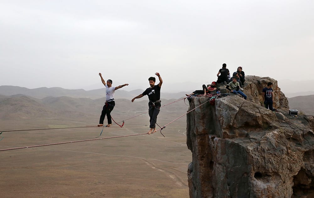 Iranian slackliners Kiavash Sharifi and Mohammad Reza Abaee walk on a slackline anchored between two rocks for a practice as their friends follow on the mountains near the city of Arak, some 204 miles (330 kilometers) southwest of Tehran, Iran. 