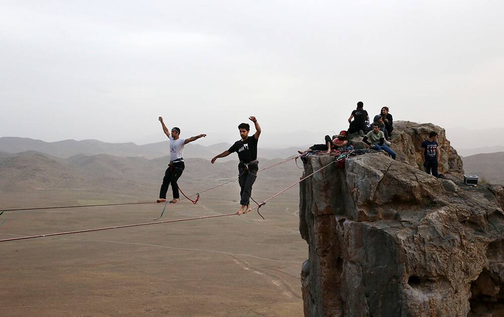 Iranian slackliners Kiavash Sharifi and Mohammad Reza Abaee walk on a slackline anchored between two rocks for a practice as their friends follow on the mountains near the city of Arak, some 204 miles (330 kilometers) southwest of Tehran, Iran. 