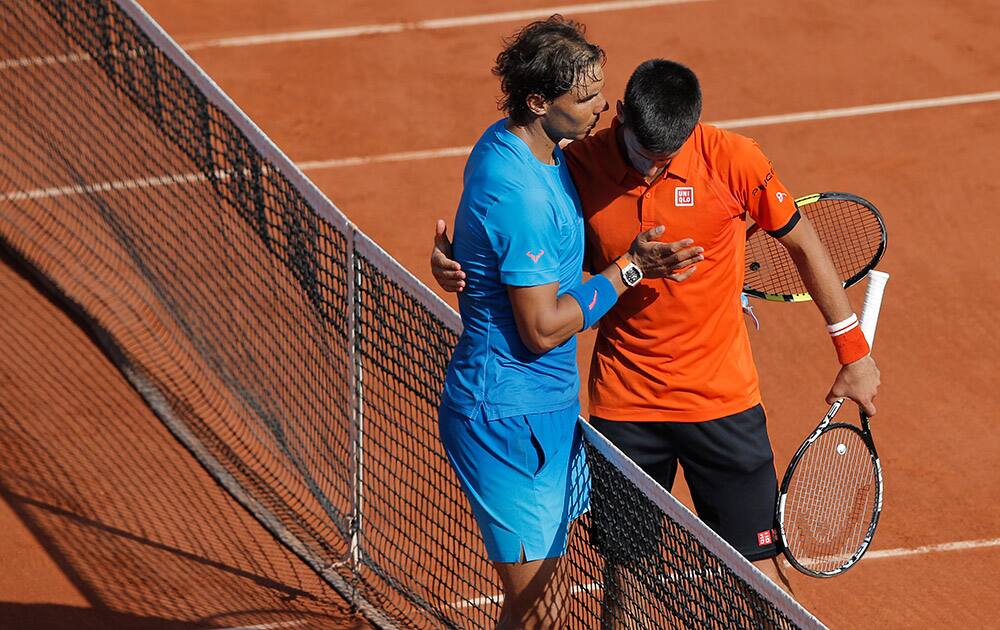 Serbia's Novak Djokovic hugs Spain's Rafael Nadal after winning the quarterfinal match of the French Open tennis tournament in three sets, 7-5, 6-3, 6-1, at the Roland Garros stadium, in Paris, France.