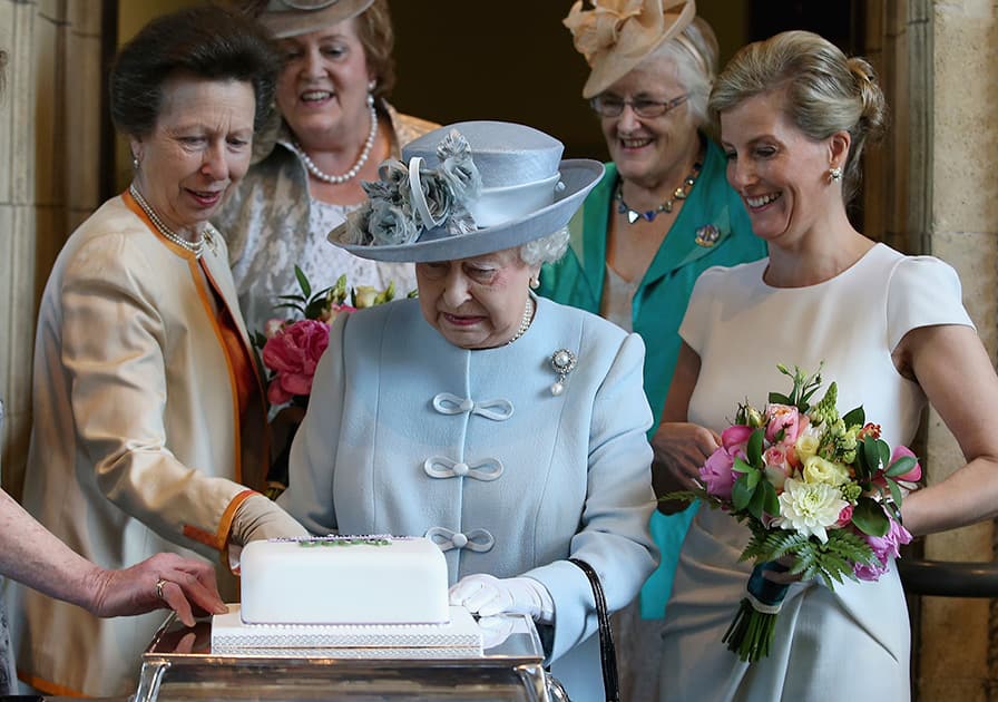 Britain's Sophie, Countess of Wessex and Princess Anne, look on as Queen Elizabeth II, centre. prepares to cut a Women's Institute Celebrating 100 Years cake at the Centenary Annual Meeting of The National Federation of Women's Institute at the Royal Albert Hall in London.