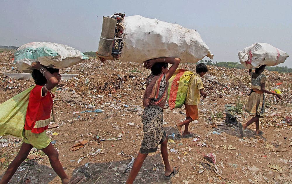 Rag pickers returning home after collecting recyclable items from an open garbage dump on the eve of World Environment Day at Sian in Birbhum district of West Bengal.