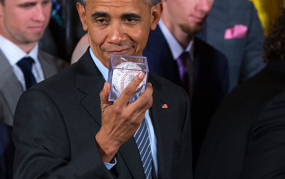 President Barack Obama shows off an autographed baseball given to him by the San Francisco Giants during a ceremony in the East Room of the White House in Washington, where he honored the 2014 World Series champion San Francisco Giants baseball team.