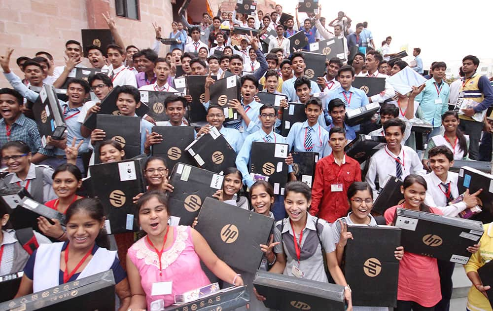 Lucknow: Students after receiving laptops from UP Chief Minister Akhilesh Yadav at a function.