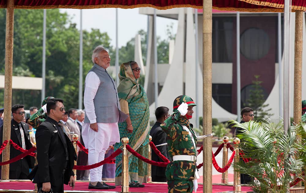Prime Minister Narendra Modi inspects a Guard of Honor, with Bangladesh’s Prime Minister Sheikh Hasina by his side at the Hazrat Shahjalal International airport in Dhaka, Bangladesh.