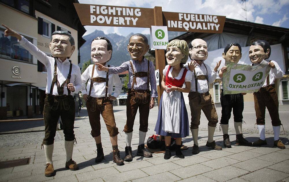 Demonstrators wear masks of Canadian Prime Minister Stephen Harper, British Prime Minister David Cameron, U.S. President Barack Obama, German Chancellor Angela Merkel, French President Francois Hollande, Japanese Prime Minister Shinzo Abe and Italian Prime Minister Matteo Renzi, from left, during a Oxfam demanding the fight against poverty in Garmisch-Partenkirchen, southern Germany.