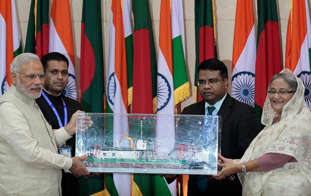 Indian Prime Minister Narendra Modi hands over a model of a ship to Bangladesh’s Prime Minister Sheikh Hasina in Dhaka, Bangladesh.