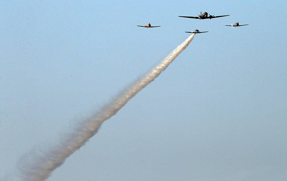 Cavanaugh Flight Museum aircraft fly over the track during the playing of the national anthem before the Firestone 600 IndyCar auto race at Texas Motor Speedway, in Fort Worth, Texas. 