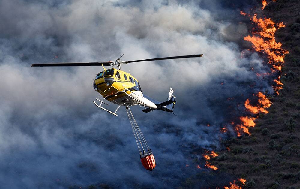 Emergency responders dump water onto a wildfire, near Celebration Park south of Melba, Idaho.