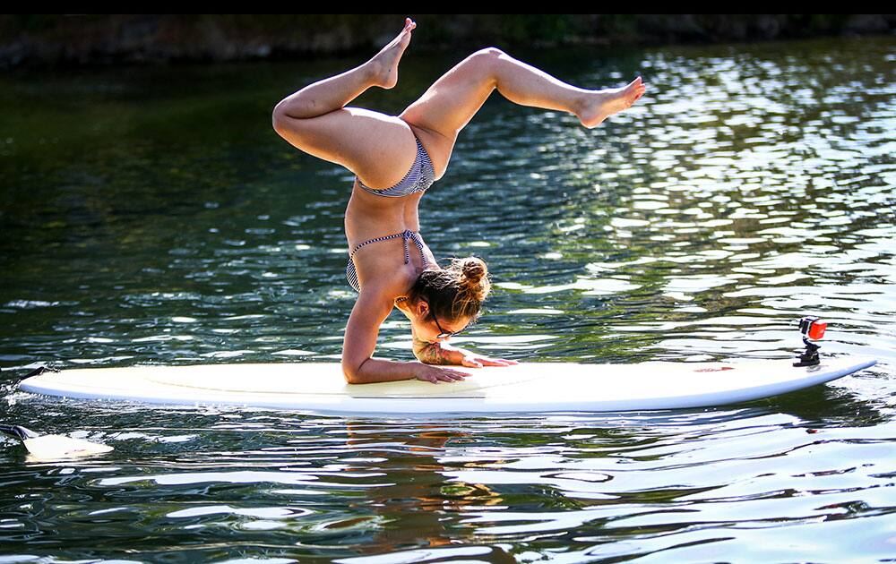 Nina Lascano practices her balance while on a paddle board floating on Lake Union in Seattle.