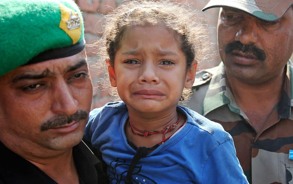 A army soldier holds four years old Janvi, daughter of his colleague Randeep Singh, who was killed in Thursday’s rebel attack in northeastern Manipur state after his body was brought to Akhnoor, Jammu and Kashmir state, India.