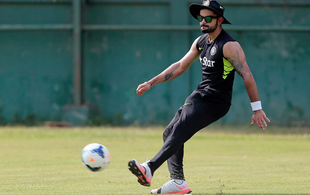 Virat Kohli plays with a soccer ball during a practice session ahead of their test cricket match against Bangladesh in Dhaka, Bangladesh.