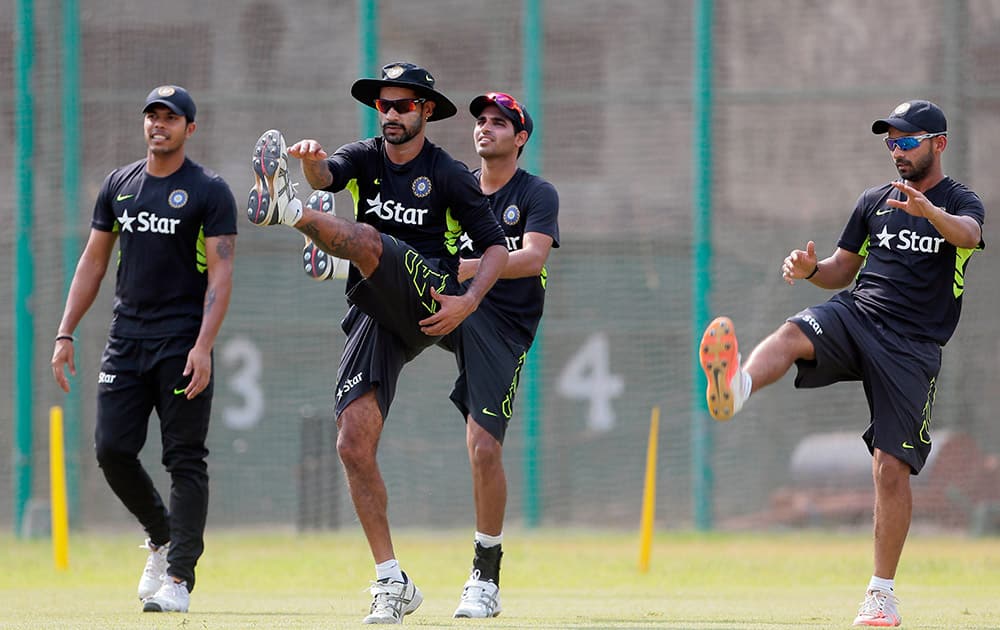 Indian players, Varun Aaron, Shikhar Dhawan, Bhuvneshwar Kumar and Ajinkya Rahane stretch during a practice session ahead of their test cricket match against Bangladesh in Dhaka, Bangladesh.