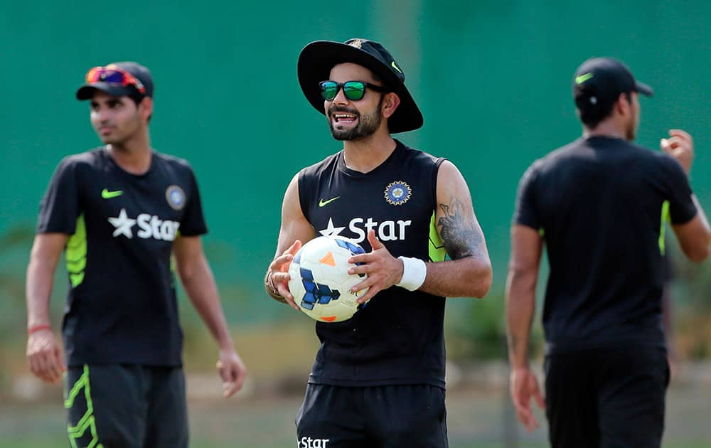 Virat Kohli holds a soccer ball during a practice session ahead of their test cricket match against Bangladesh in Dhaka, Bangladesh.