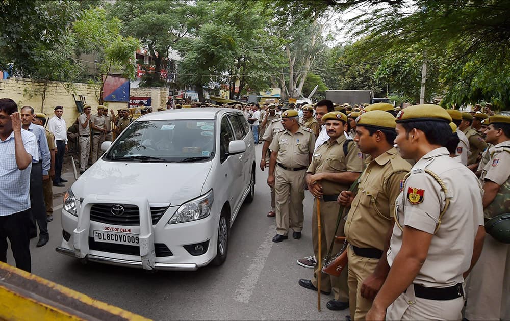 Policemen standing near Delhi Law Minister Jintender Singh Tomars vehicle at the ATS Office Vasant Vihar where he was being questioned following his arrest in alleged fake degree case in New Delhi.