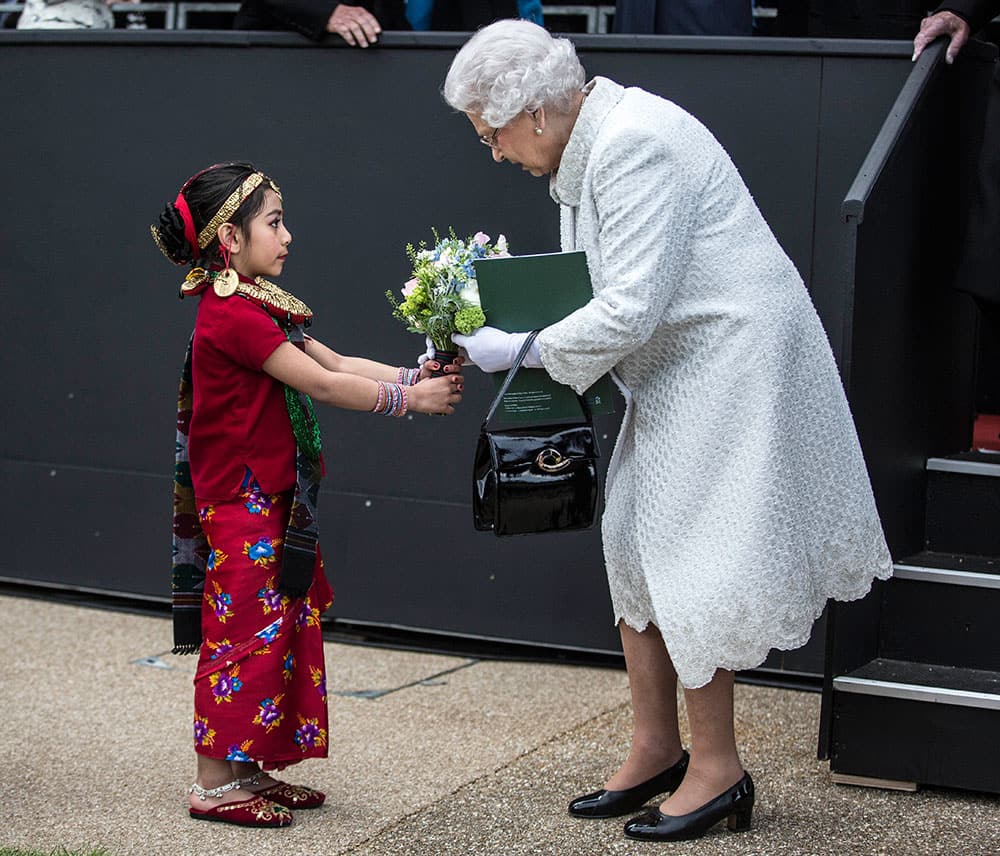 Britain's Queen Elizabeth II receives a bouquet of flowers from Swechya Joshi, the daughter of a serving Gurkha after a pageant to celebrate 200 years of Gurkha service to the British Crown in London.