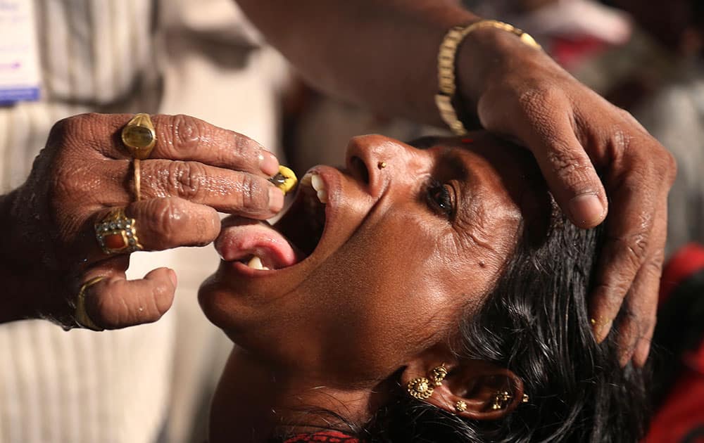 a member of the Goud family administers “fish medicine” to an asthma patient in Hyderabad, India. 