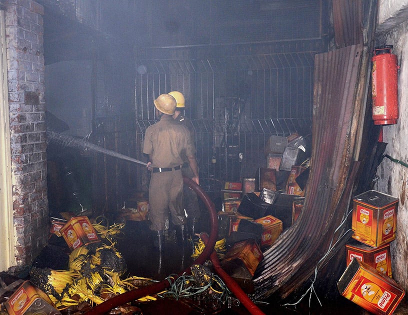 Fire fighters extinguishing a blaze at a mustard oil factory in Manicktala in Kolkata.