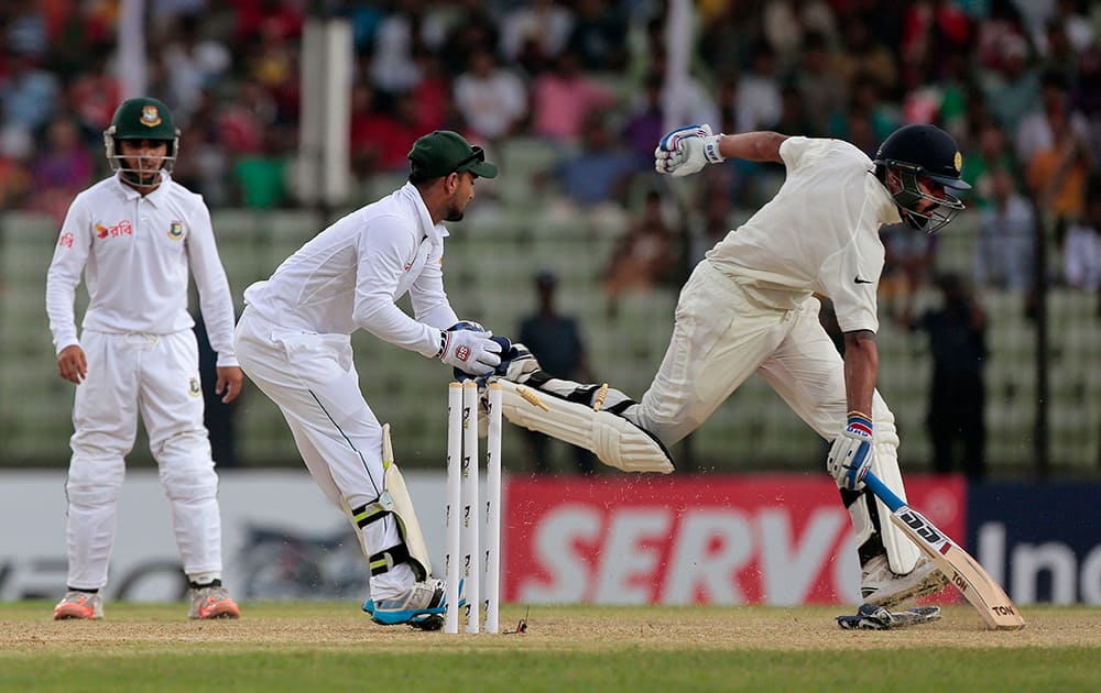 Murali Vijay, makes his ground as Bangladesh’s wicketkeeper Litton Das, center, attempts to run him out during the test cricket match between them in Fatullah, Bangladesh.