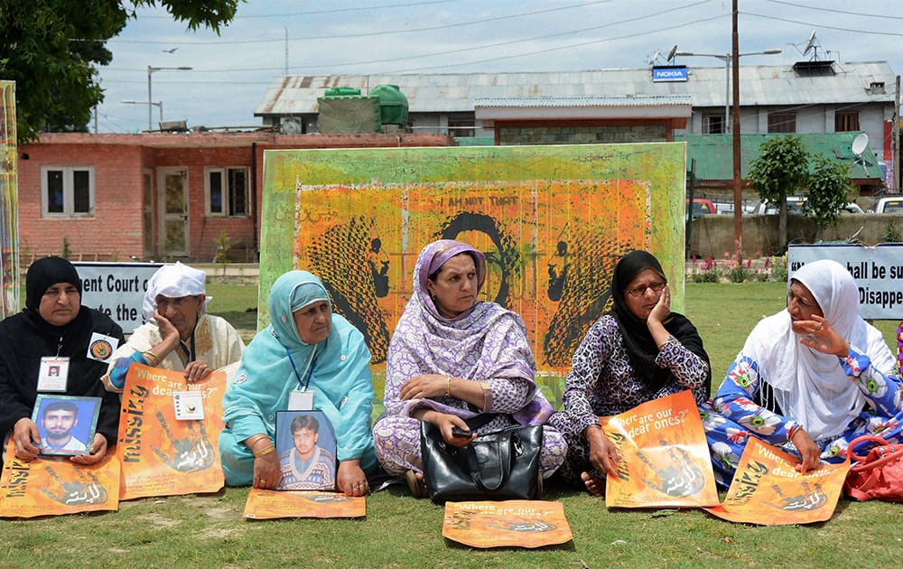 Relatives of missing persons holding photographs and placards during a silent sit-in protest for the whereabout of their dear ones, at Partap Park in Srinagar.