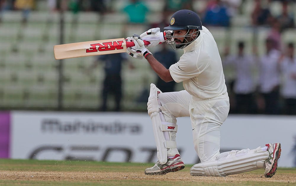 Shikhar Dhawan, plays a shot during the first day of their test cricket match against Bangladesh in Fatullah, Bangladesh.