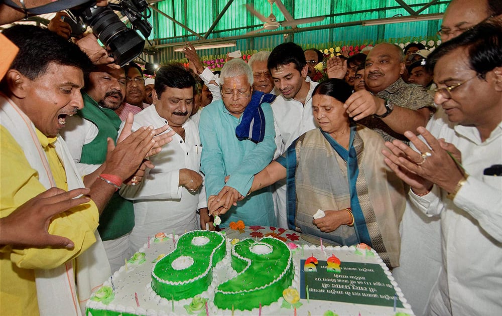 RJD chief Lalu Prasad cutting a cake with his wife Rabri Devi, family members and supporters on his 68th birthday.