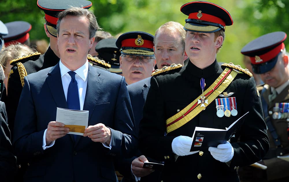 Prince Harry and Britain's Prime Minister, David Cameron, sing a hymn during a Service of Dedication to inaugurate the Bastion Memorial, and remember those who lost their lives during combat operations in Afghanistan, at the National Arboretum, Alrewas, England.