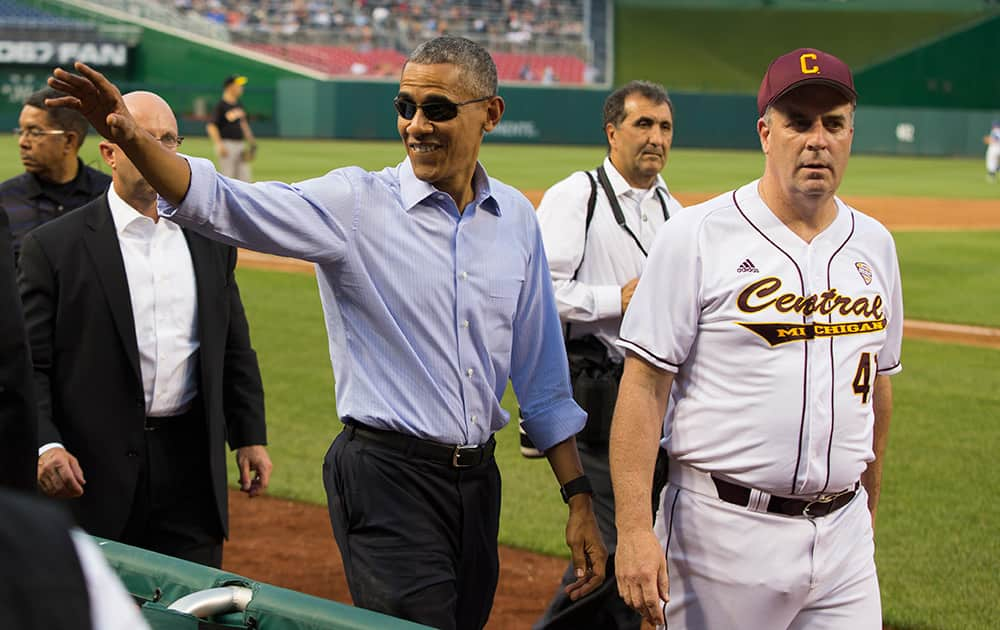 President Barack Obama walks with Rep. Dan Kildee, D-Mich., as he makes a visit to the Congressional baseball game at Nationals Park in Washington.