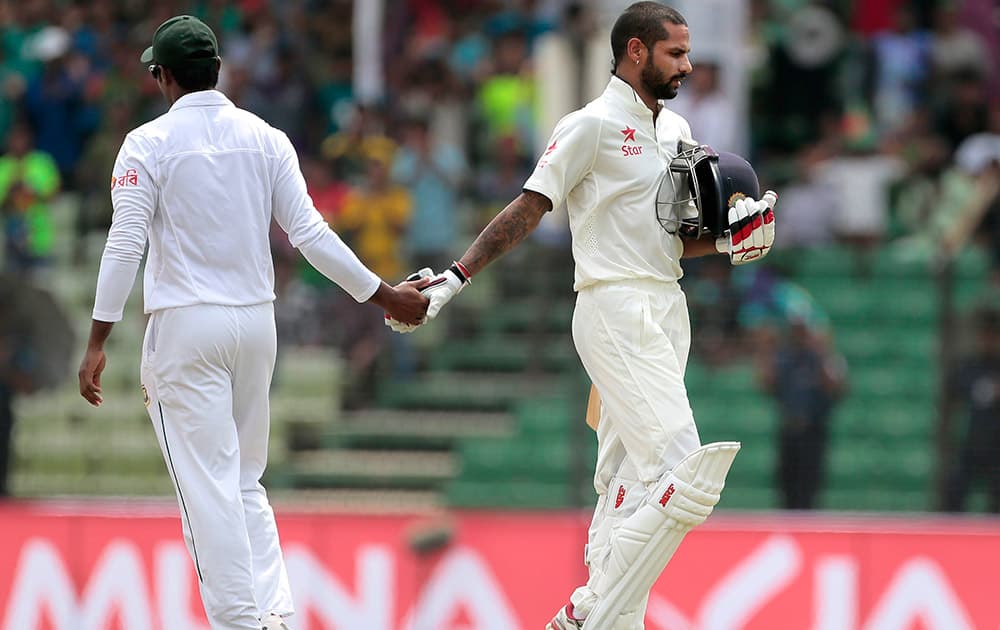 Shikhar Dhawan shakes hand with a Bangladeshi player as he leaves after getting out during the third day cricket match in Fatullah, Bangladesh.