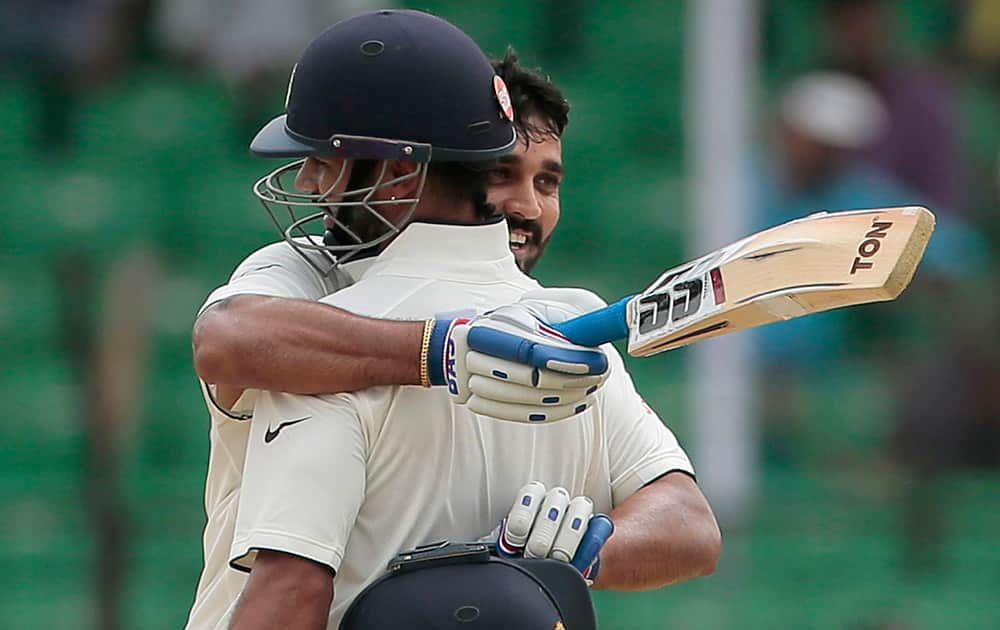 Murali Vijay hugs his teammate Shikhar Dhawan after scoring a century during the third day test cricket match against Bangladesh in Fatullah, Bangladesh.