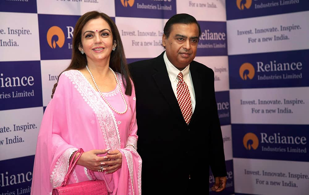 Mukesh Ambani, chairman and managing director of the Reliance Industries Ltd., with his wife Nita pose for a photo as they arrive for the 41st Reliance Industries AGM meet in Mumbai.