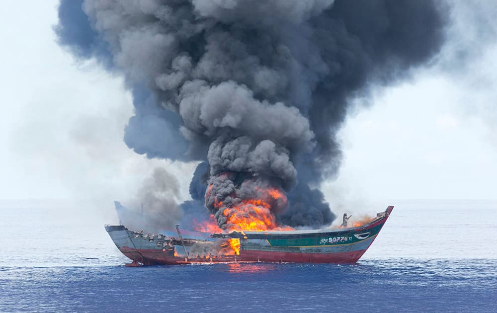 Columns of black smoke rise from two Vietnamese boats in the waters off Palau. The tiny Pacific nation of Palau, fighting a rising tide of illegal fishing in its waters, set fire to the four boats of Vietnamese caught poaching sea cucumbers and other marine life in its waters.