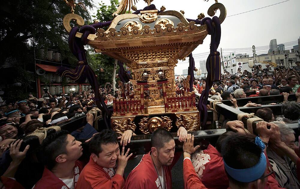 Local residents chant and carry on their shoulders 'mikoshi,' or portable shrine during a festival in Tokyo.