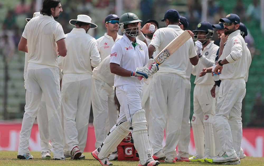 Bangladesh’s Tamim Iqbal, center, walks back to the pavilion after his dismissal by India’s Ravichandran Ashwin during the fourth day of their test cricket match in Fatullah, Bangladesh.