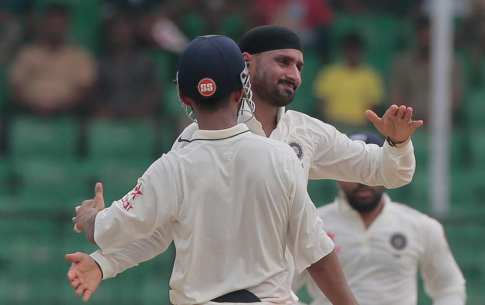 Harbhajan Singh, face to the camera, celebrates with his teammates after the dismissal of Bangladesh’s Mominul Haque during the fourth day of their test cricket match in Fatullah, Bangladesh.