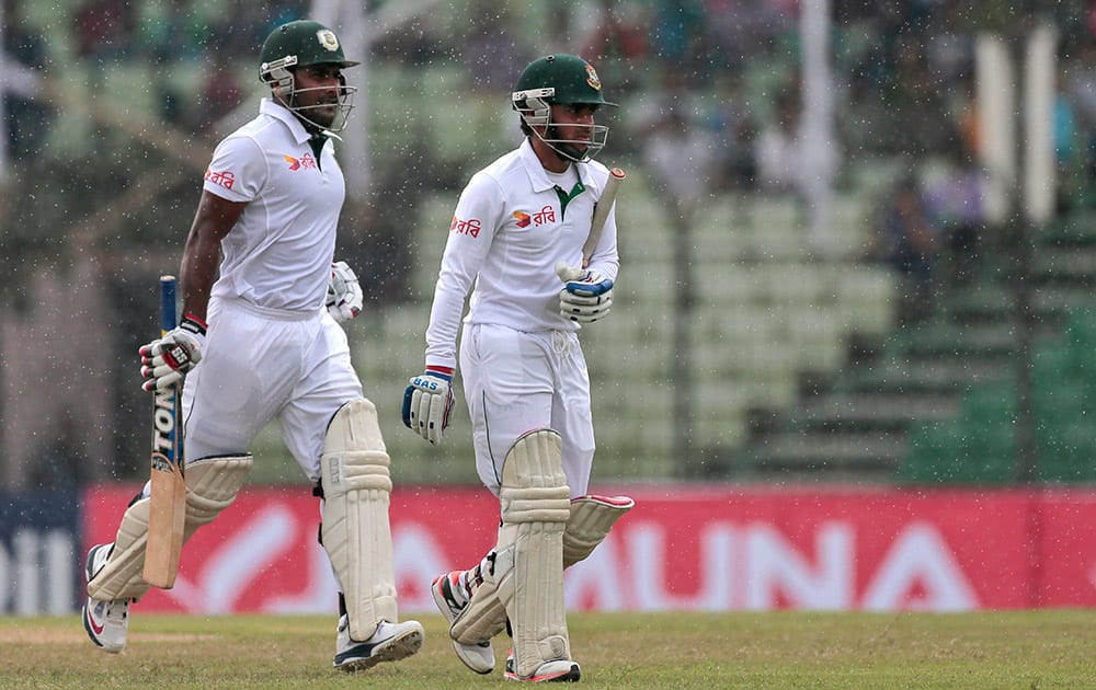 Bangladesh’s Mominul Haque, right, and Imrul Kayes walk back to the pavilion as rain interrupts play during the fourth day of their test cricket match against India in Fatullah, Bangladesh.