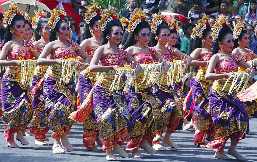Indonesian dancers in traditional costumes perform during a parade to mark the Bali Arts Festival in Bali, Indonesia. Performances are scheduled daily during the month-long annual festival held from June 13 to July 12.