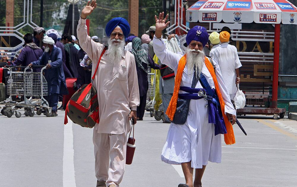 Indian Sikh pilgrims wave as they enter into Pakistan after crossing the Wagah border post near Lahore, Pakistan. Hundreds of Sikh pilgrims arrived in Pakistan on Saturday to attend the 408th anniversary of the death of the fifth Sikh Guru, Arjan Dev Ji, that is celebrated in Derah Sahib.
