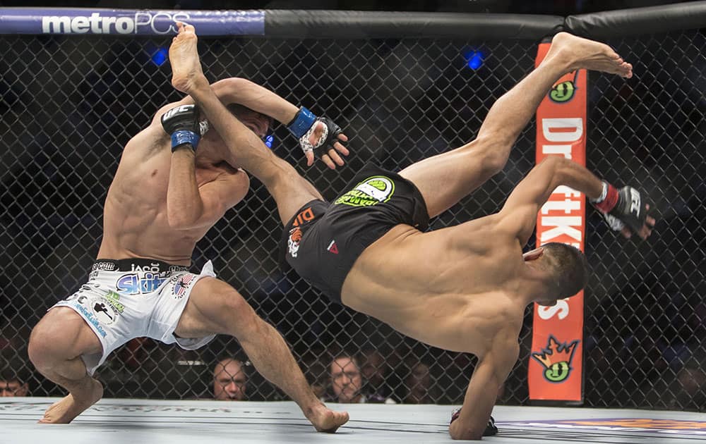 Charles Rosa, left, of the United States battles against Mexico´s Yair Rodriguez during a men's Featherweight UFC 188 mixed martial arts bout in Mexico City.