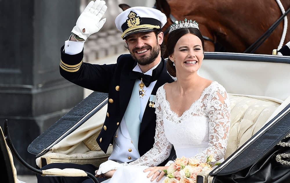 Sweden's Prince Carl Philip sits with his bride, Sofia Hellqvist in a carriage, after their wedding ceremony, in Stockholm, Sweden.