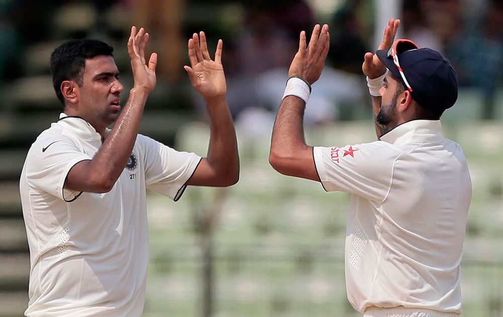 India’s Ravichandran Ashwin, left, celebrates with captain Virat Kohli after the dismissal of Bangladesh’s Shuvagata Hom on the last day of the test cricket match between them in Fatullah, Bangladesh.