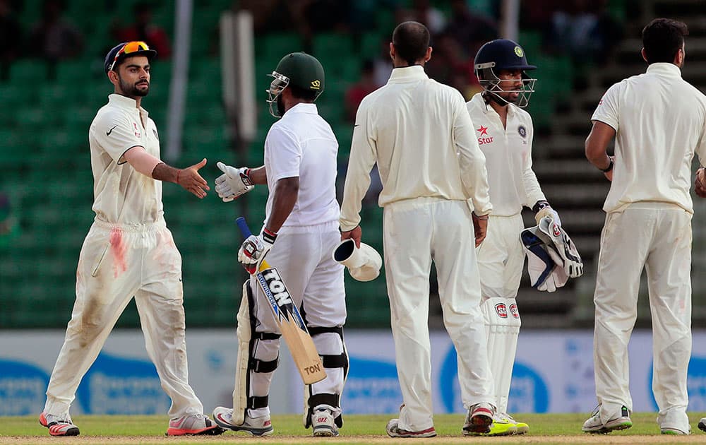 India’s captain Virat Kohli, left, shakes hand with Bangladesh’s Imrul Kayes, second left, at the end of the final day of their cricket test match in Fatullah, Bangladesh.