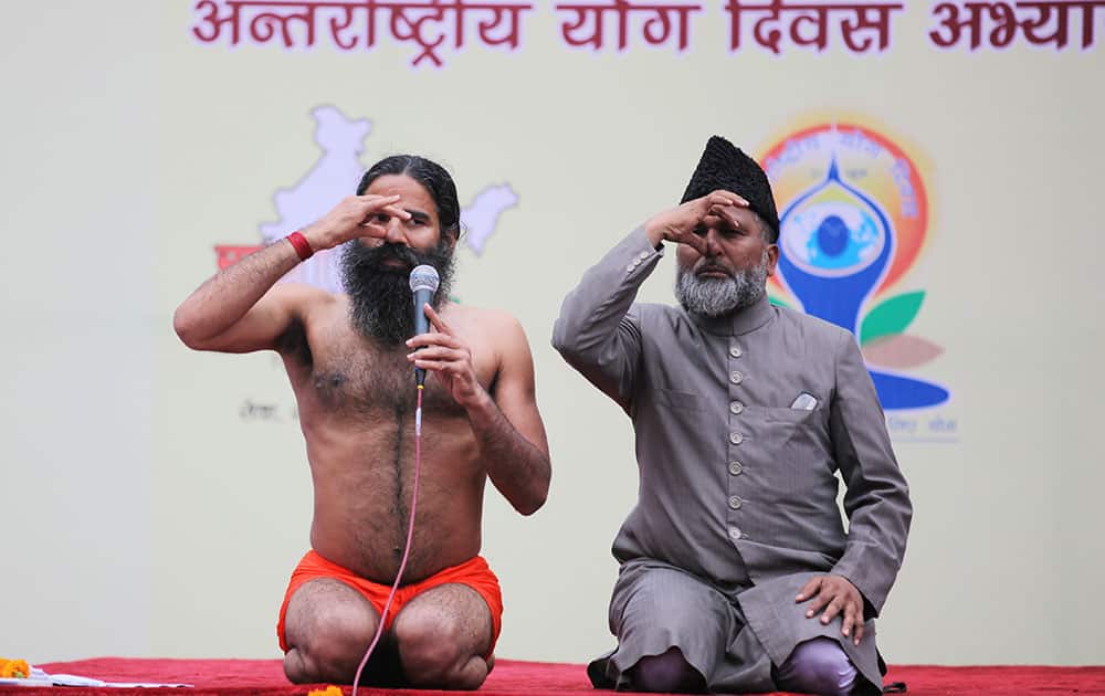 yoga guru Baba Ramdev, left, and former All India Imams Organisation general secretary and now a former member of the India Against Corruption core committee Mufti Shamoon Qasmi perform Anulom Vilom or Alternate Nostril Breathing exercises during a practice session ahead of International Day of Yoga in New Delhi.